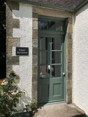 a green door of a house with a sign at Gorgeous boutique off-grid cottage near Peebles in Peebles