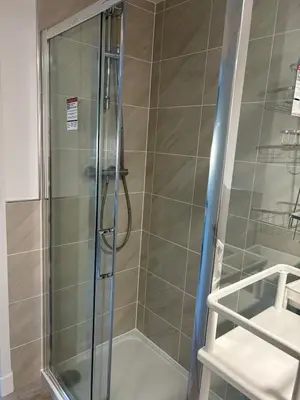 a shower with a glass door in a bathroom at private Studio with its own kitchen and bathroom in Moffat