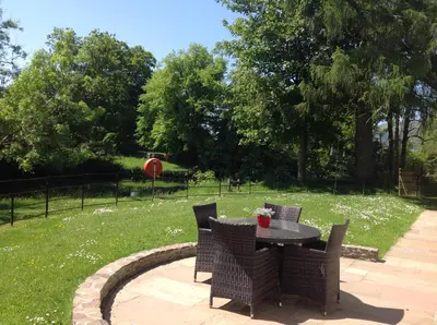 a table and chairs sitting on a patio in a yard at Lovely Riverside Holiday Home in Callander