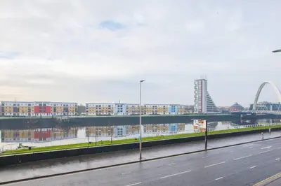 an empty street with a view of a city and the gateway arch at Apartment with river view next to hydro in Glasgow