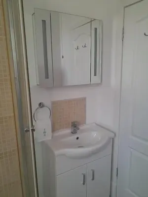 a bathroom with a white sink and a mirror at Doune 3 Outlander Apartment 1st floor in Stirling