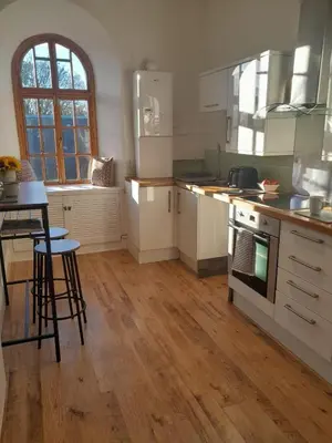 a kitchen with white appliances and a wooden floor at Doune 3 Outlander Apartment 1st floor in Stirling