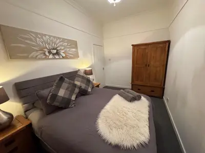 a bedroom with a bed with a rug on it at Hillhead Apartment in Coylton