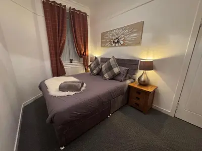 a small bedroom with a bed and a night stand at Hillhead Apartment in Coylton
