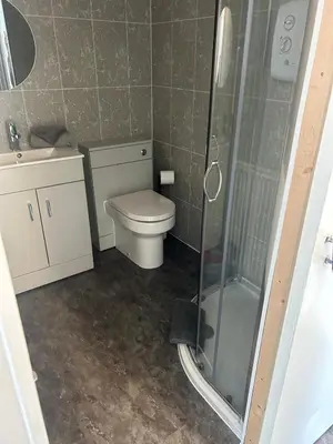 a small bathroom with a toilet and a shower at Hillhead Apartment in Coylton