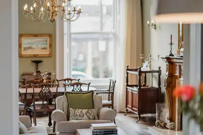 a living room with a chandelier and a table at Prestigious Townhouse close to Princes Street in Edinburgh