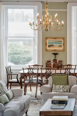 a living room with a chandelier and a table and chairs at Prestigious Townhouse close to Princes Street in Edinburgh