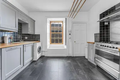 a large kitchen with white appliances and a window at Super Spacious 4 Bed, sleeps 6 in Edinburgh