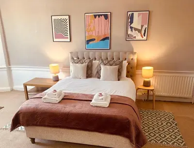a bedroom with a large bed with two towels on it at Super Spacious 4 Bed, sleeps 6 in Edinburgh