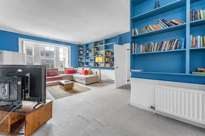 a living room with blue walls and a tv at Super Spacious 4 Bed, sleeps 6 in Edinburgh
