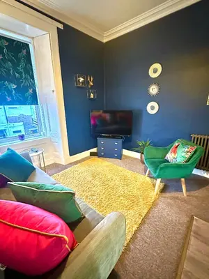 a living room with a couch and a chair at Small Cosy Flat in Helensburgh