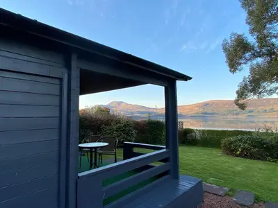 a cabin with a table and a view of a lake at Lochside-1Bed-Pet Friendly-Amazing views in Alexandria