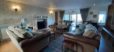 a living room with two couches and a fireplace at Marshill Farmhouse in Blackwood