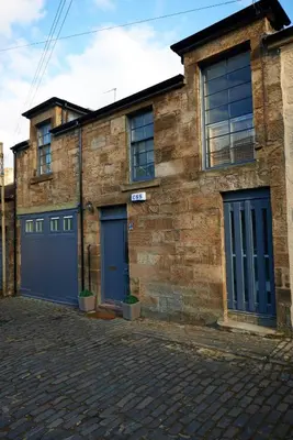 a brick building with two blue doors on a street at Park Mews Glasgow in Glasgow