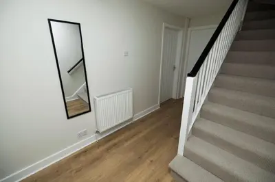a stairway with a mirror and a stair case at Pristine 3 bedroom house in East Kilbride