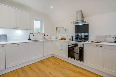 a white kitchen with white cabinets and appliances at 3 Bed in Fearnan oc-s29984 in Chesthill