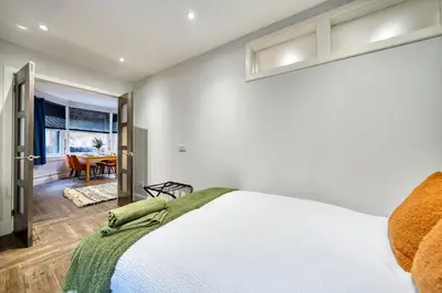 a bedroom with a bed and a dining room at Spacious 4 Bedroom Apt Near West End Glasgow in Glasgow