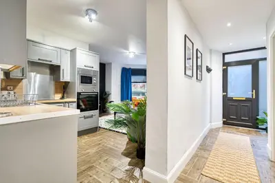 a kitchen with white cabinets and a large window at Spacious 4 Bedroom Apt Near West End Glasgow in Glasgow