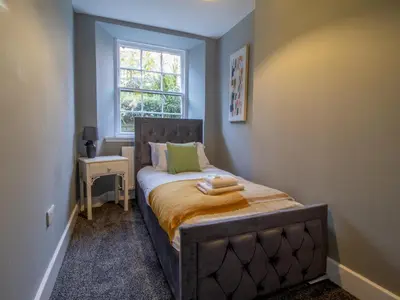 a small bedroom with a bed with a window at Happy Haven Home, West End - Pass the Keys in Glasgow