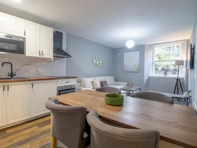 a kitchen and living room with a table and chairs at Happy Haven Home, West End - Pass the Keys in Glasgow