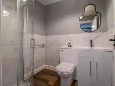 a white bathroom with a toilet and a shower at Happy Haven Home, West End - Pass the Keys in Glasgow