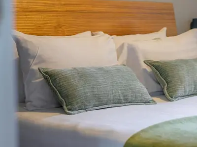 a bed with two pillows and a wooden headboard at Happy Haven Home, West End - Pass the Keys in Glasgow