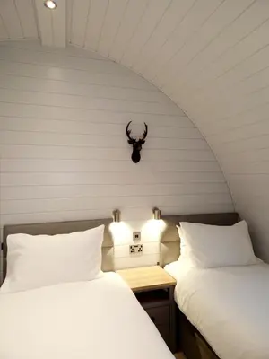 two beds sitting next to each other in a room at The Ness, Lodge with Hot Tub in Crieff