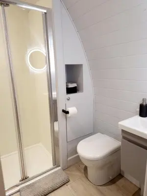 a bathroom with a shower and a toilet and a sink at The Ness, Lodge with Hot Tub in Crieff