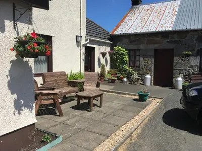 two wooden benches sitting outside of a building at Farmhouse in Clydebank
