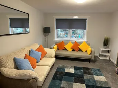 a living room with two couches with colorful pillows at Spacious 2 bedroom apartment, entire place in Greenock