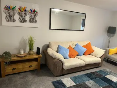 a living room with a couch and a mirror at Spacious 2 bedroom apartment, entire place in Greenock