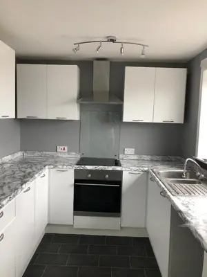 a kitchen with white cabinets and a black dishwasher at Spacious 2 bedroom apartment, entire place in Greenock