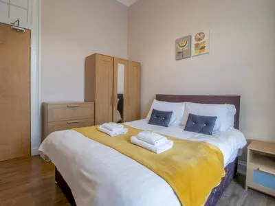 a bedroom with a large bed with two pillows on it at City Haven Main Door & Parking - Pass the Keys in Glasgow