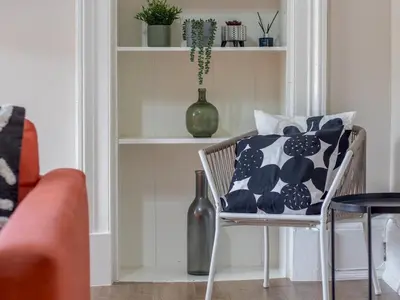 a chair with a pillow on it in a living room at City Haven Main Door & Parking - Pass the Keys in Glasgow