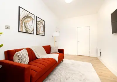 a living room with a red couch and a television at Argyl - Grassmarket Apartments in Edinburgh
