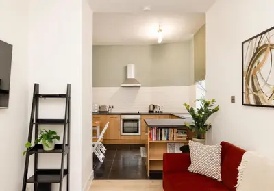 a kitchen and living room with a red couch at Argyl - Grassmarket Apartments in Edinburgh