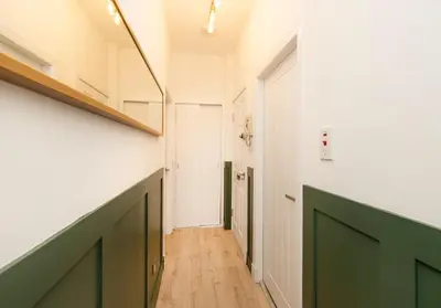 a hallway with green doors and a white wall at Argyl - Grassmarket Apartments in Edinburgh