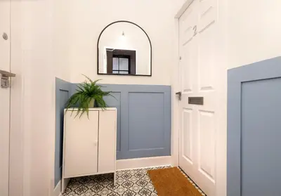 a hallway with a blue door and a mirror at Argyl - Grassmarket Apartments in Edinburgh