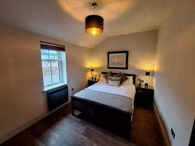 a bedroom with a large bed and a window at Luxurious Cottage Machrihanish in Drumlemble