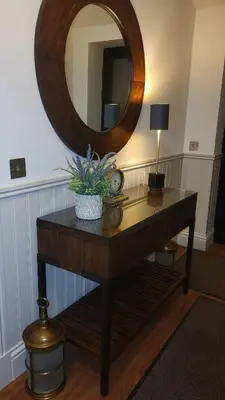 a table with a mirror and a clock on it at Luxurious Cottage Machrihanish in Drumlemble