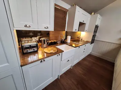 a kitchen with white cabinets and a counter top at Luxurious Cottage Machrihanish in Drumlemble