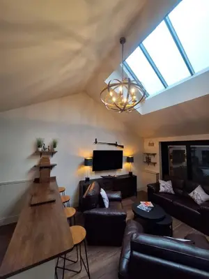 a living room with leather furniture and a large window at Luxurious Cottage Machrihanish in Drumlemble