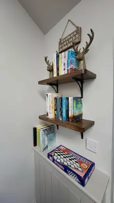 a shelf with books on a wall at Luxurious Cottage Machrihanish in Drumlemble