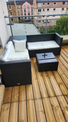 a balcony with a couch and a table on a deck at Modern Room in a Shared Flat near Haymarket in Edinburgh