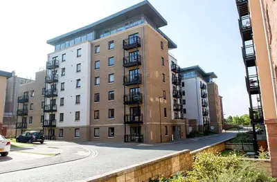 a large brick building with balconies on a street at Modern Room in a Shared Flat near Haymarket in Edinburgh