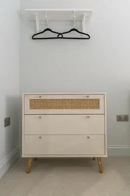 a dresser in a room with a white wall at Prime Stay Apartments in Paisley