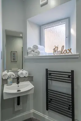 a bathroom with a sink and a mirror at Prime Stay Apartments in Paisley