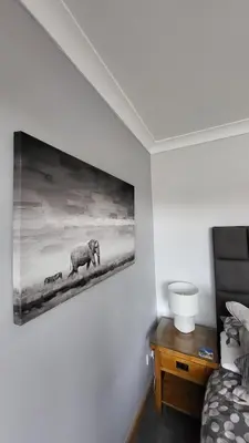 a bedroom with a painting of elephants on the wall at Cosy 2 bed home Glasgow South in Cathcart