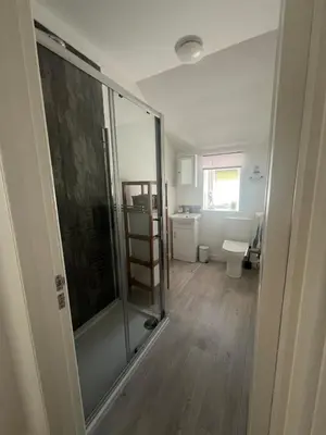 a bathroom with a shower and a toilet at Greenwood South - Luxury beachfront home with log burner in Kames
