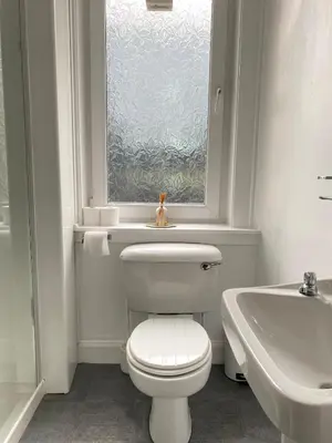 a bathroom with a toilet and a sink and a window at 1 Bed Flat Near Edinburgh Castle in Edinburgh